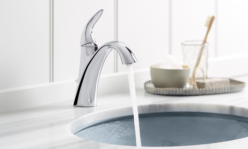Chrome bathroom faucet dispensing water